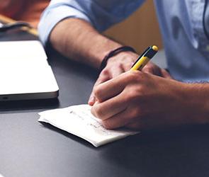 UB students writing in a notebook